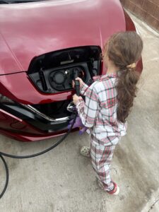 girl plugging in ev